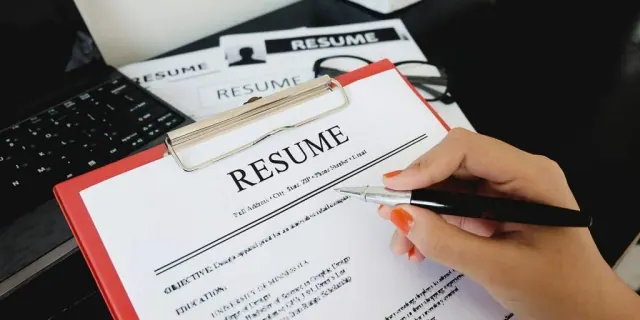 A person reviewing a printed resume