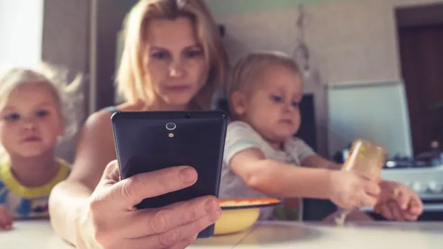 An adult holding a phone near children