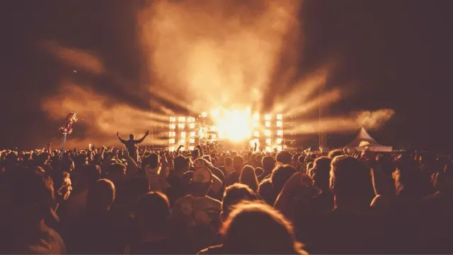 An audience watching a brightly lit concert stage