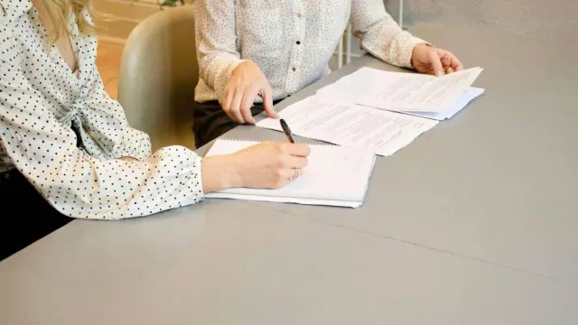 Two people reviewing papers at a table