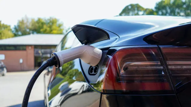 Charging connector attached to a dark-colored electric car