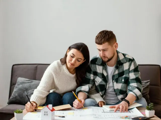 Two people working through household paperwork