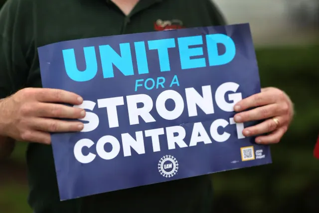 A person holding a United for a Strong Contract sign