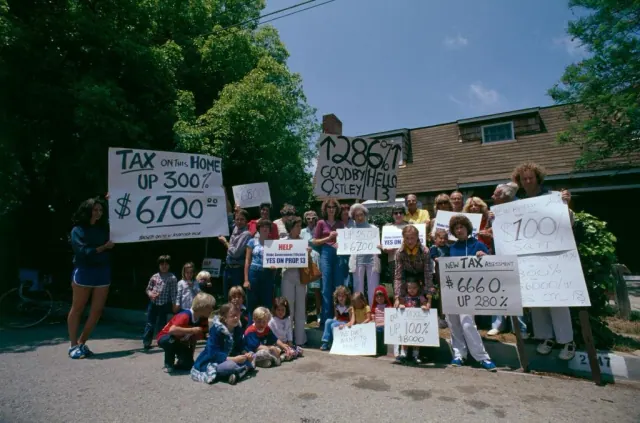 People holding signs protesting property tax increases