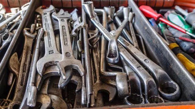 An open tray containing assorted metal spanners