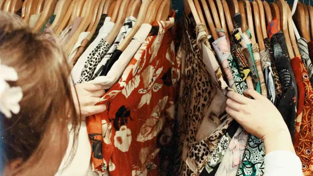 A person looking through clothes on a rail