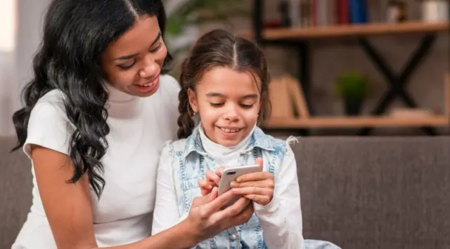 An adult and child looking at a phone