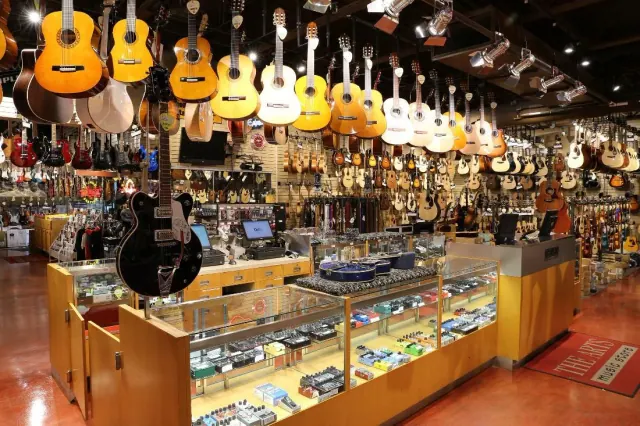 Photograph of a music store with guitars hanging from the ceiling