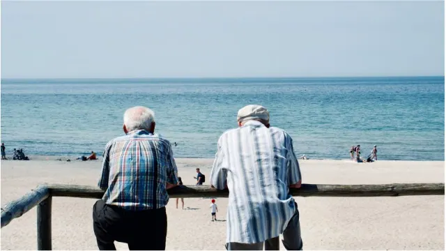 Two older people looking out over a beach