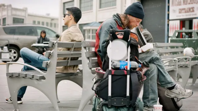 People and luggage near public seating