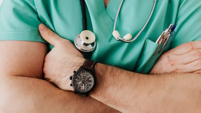 A person in green medical scrubs wearing a stethoscope