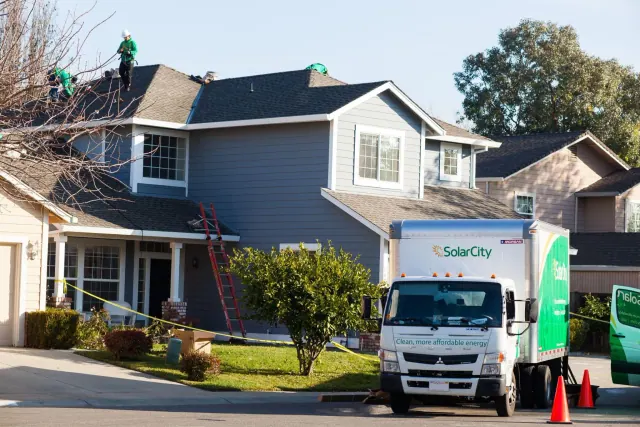 A work vehicle parked outside a house