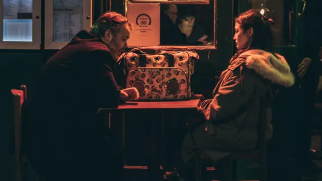 Two people talking in a dimly lit room