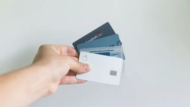 A hand holding several payment cards