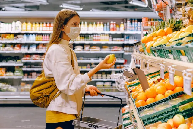A shopper selecting produce