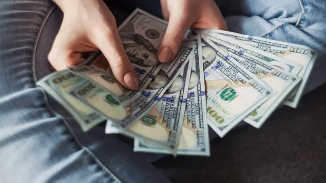 Hands holding U.S. banknotes