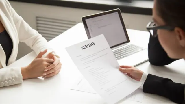 A person handing over a resume during an interview