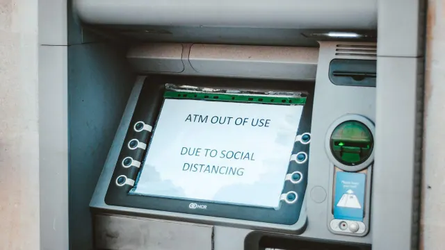 An ATM displaying an out-of-use notice about social distancing