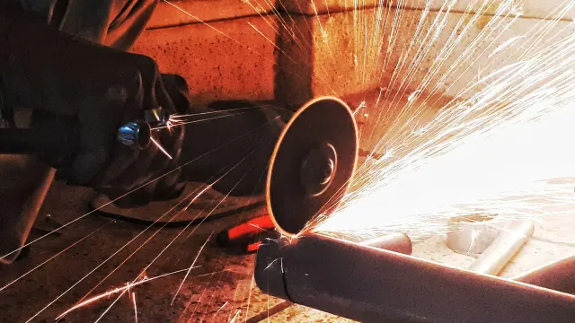 A power grinder throwing sparks while cutting metal