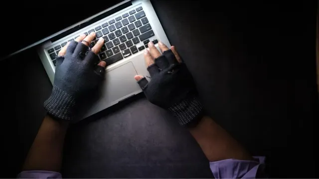 Hands using a laptop in low light