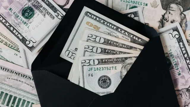 US dollar bills in envelopes