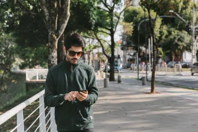 A person using a phone on a city sidewalk
