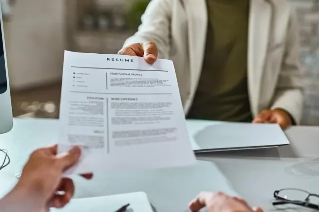 A candidate handing over a resume