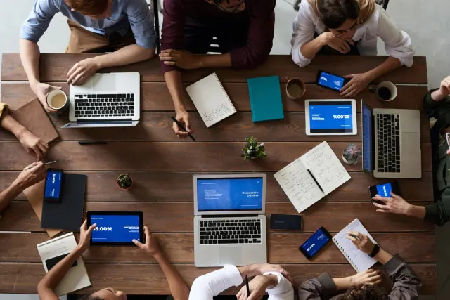 People working around a table with laptops