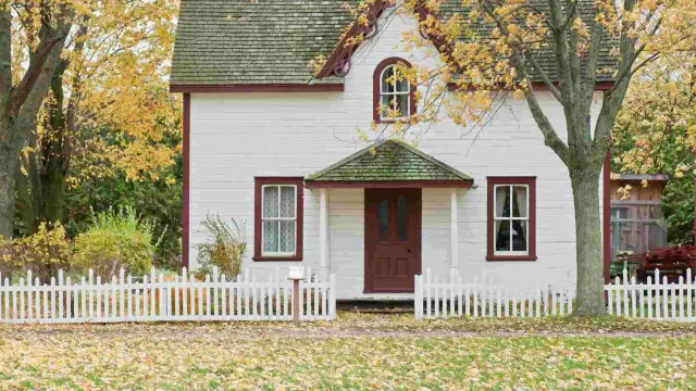 A small house with a white picket fence