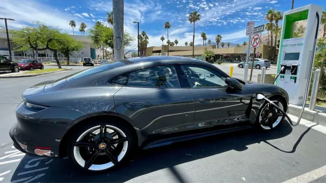 A gray electric car connected to a public charging station