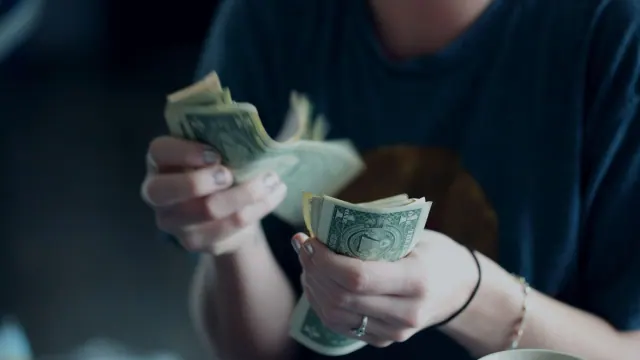 A person counting US dollar bills