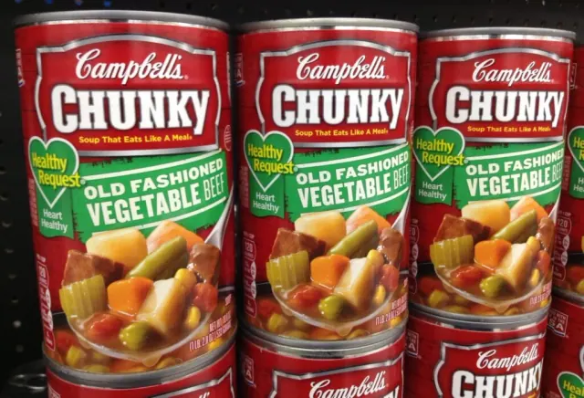 three cans of campbells soup cans on a shelf. campbells soup is one of the many items thathas been effected by skrinkflation in recent years,
