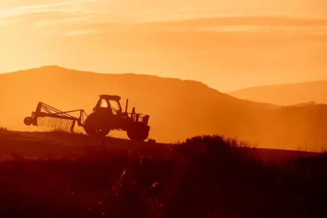 Farm equipment at sunset