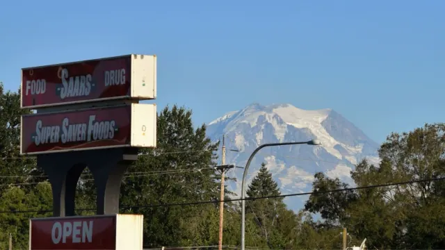 A roadside sign and distant mountain