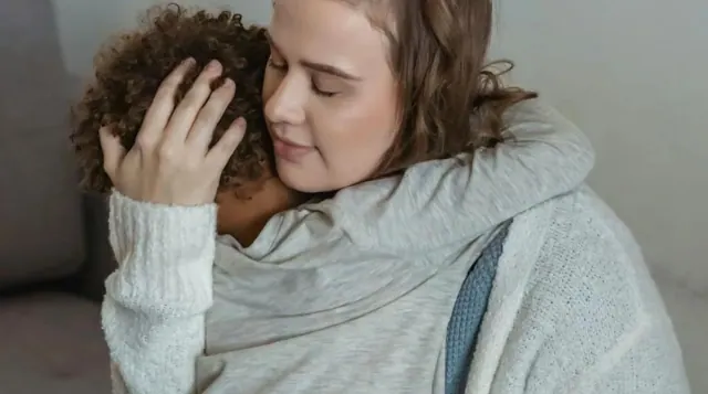 An adult comforting a child