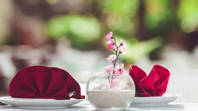 A table decorated with red napkins and flowers