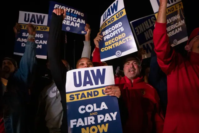 UAW demonstrators holding signs calling for COLA and fair pay