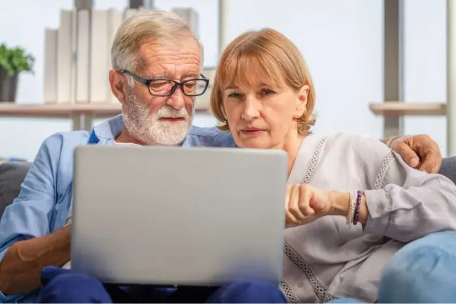 An older couple looking at a laptop