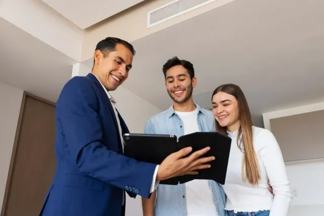 Three adults looking at a tablet in a home