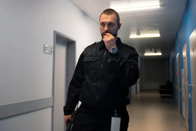 A federal agent is pictured walking through a corridor as he speaks into his headpiece