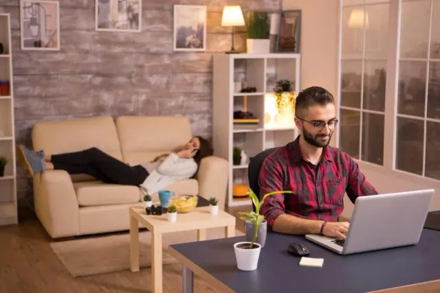 A person working at home while another rests