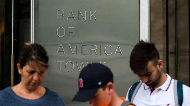 People walking in front of a Bank of America building