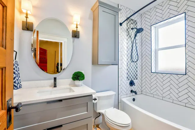 bathroom interior photo including vanity, toilet, shower, light fixtures