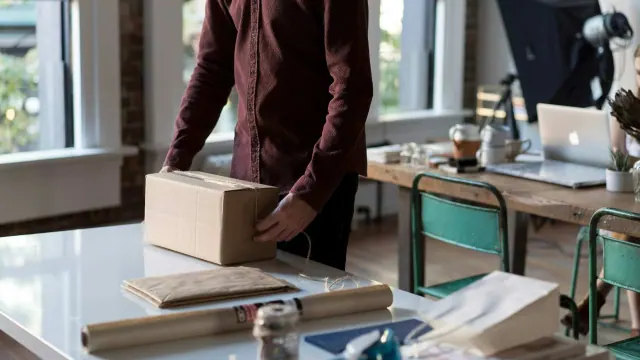 A person handling a box in a workspace