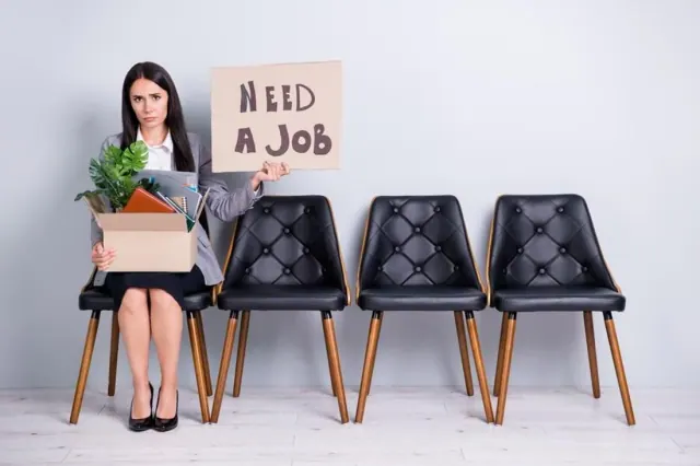 A staged job-seeker image with a sign