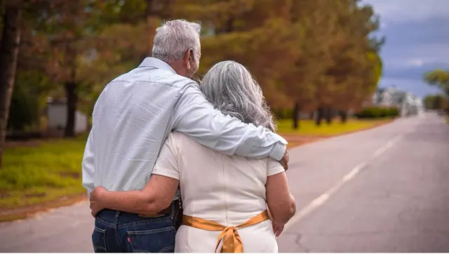 Two older people walking together