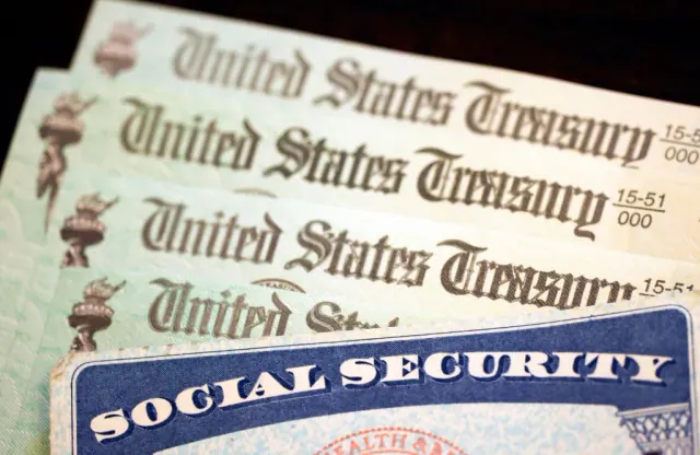 Social Security cards laid over United States Treasury checks