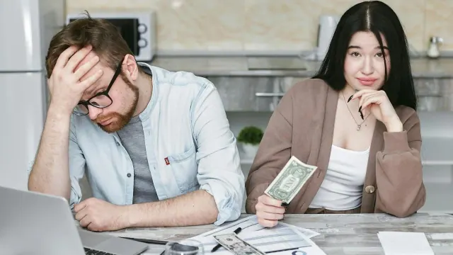 Two people sitting with cash at a table