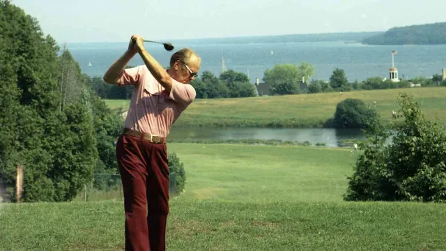 A golfer taking a swing on a green course