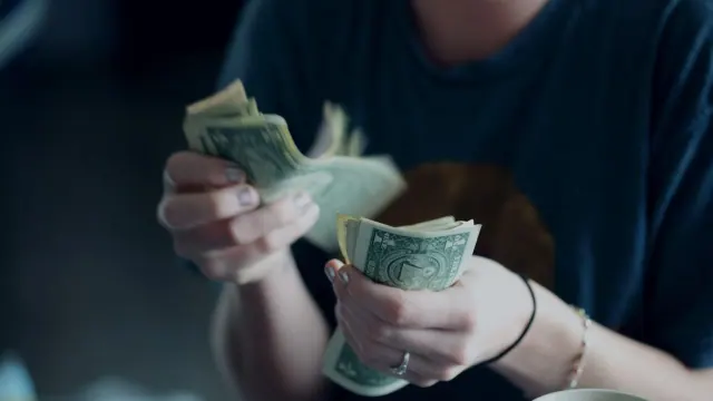 A woman sat counting through some money.